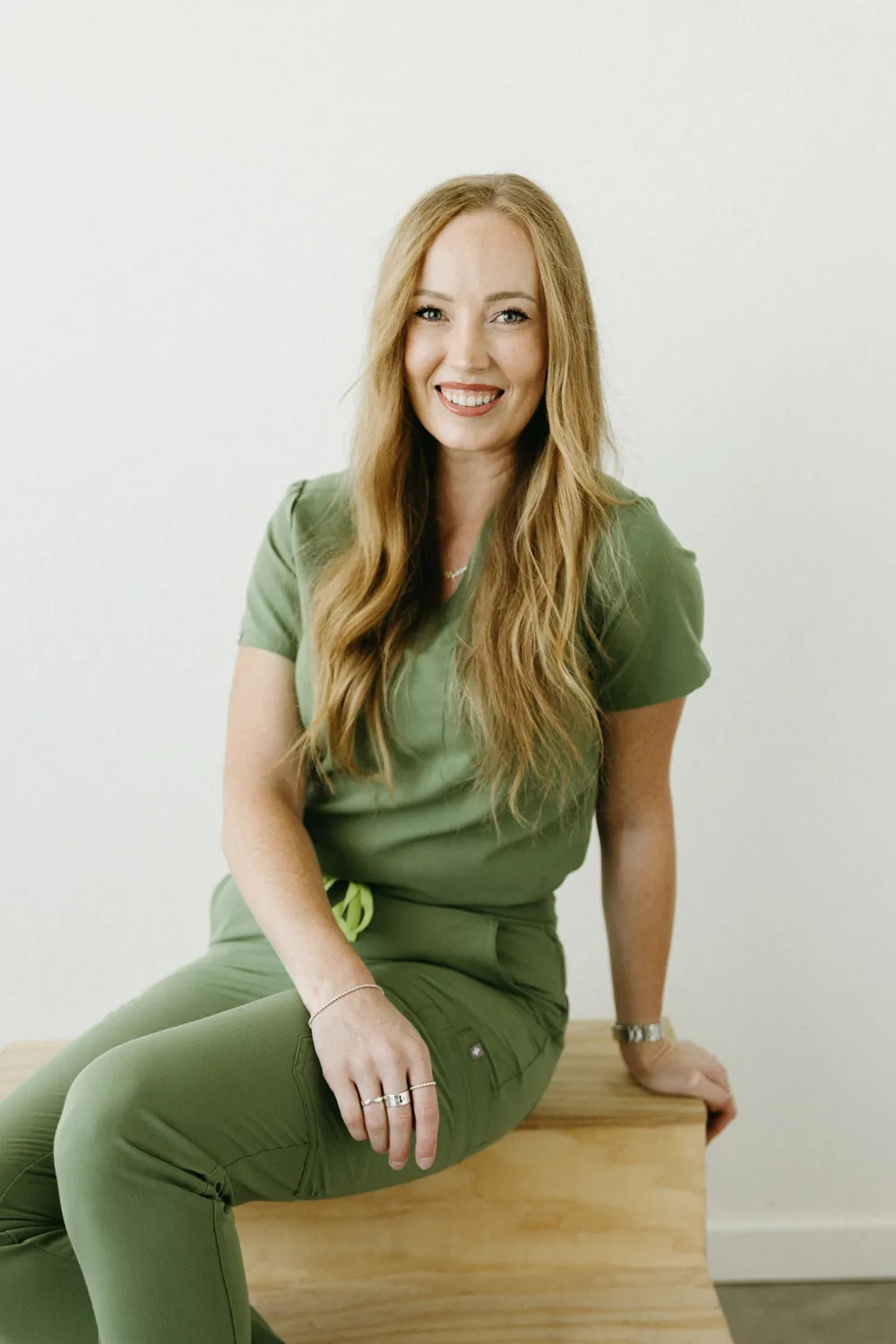 Madisen in green scrubs sitting in the studio